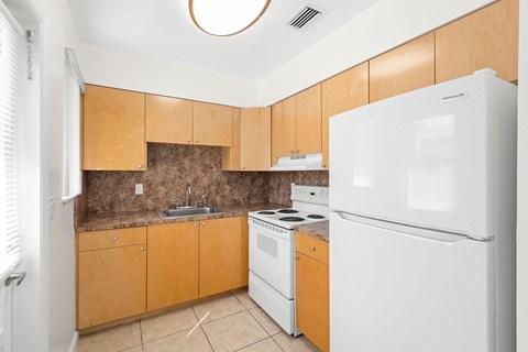a kitchen with white appliances and wooden cabinets