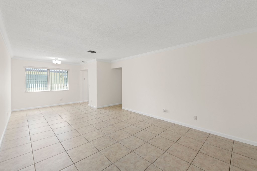 the spacious living room with tiled floors and white walls