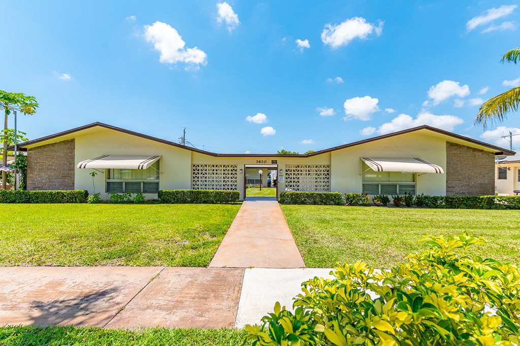 a house with a lawn and a sidewalk in front of it