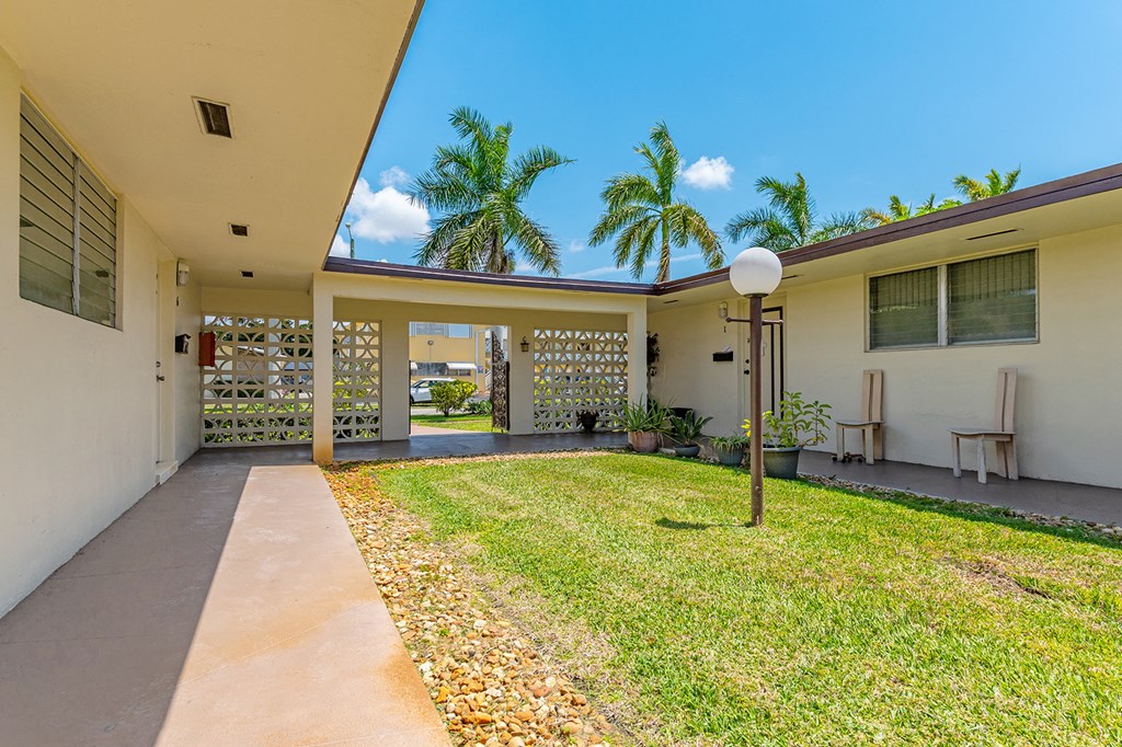 a yard in front of a house with palm trees
