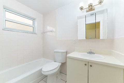 A white bathroom with a toilet, sink, and tub.