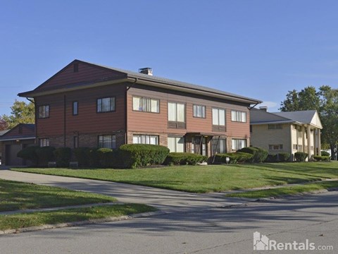 A large two-story house with a red brick exterior and a white garage door.