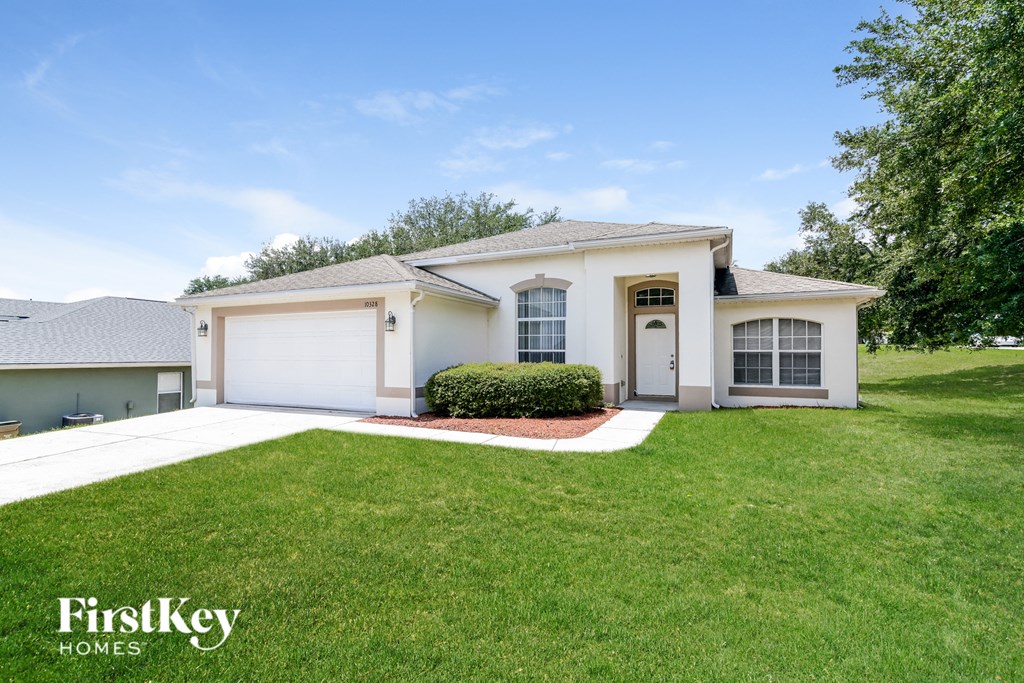a white house with a lawn and a white garage door