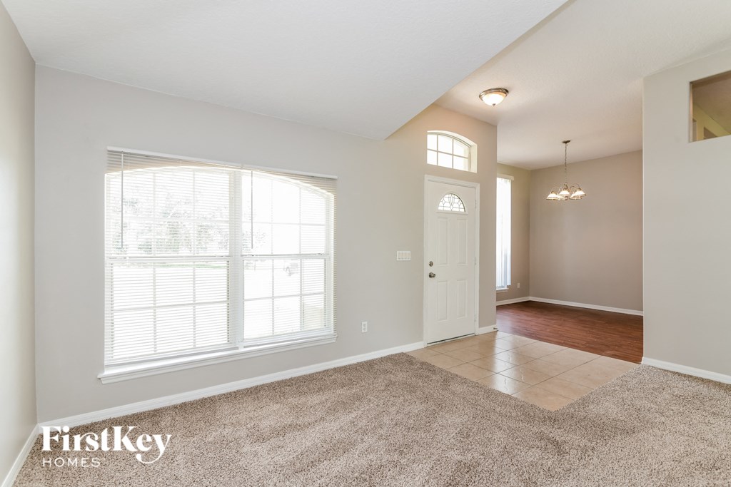 a living room with a large window and a white door