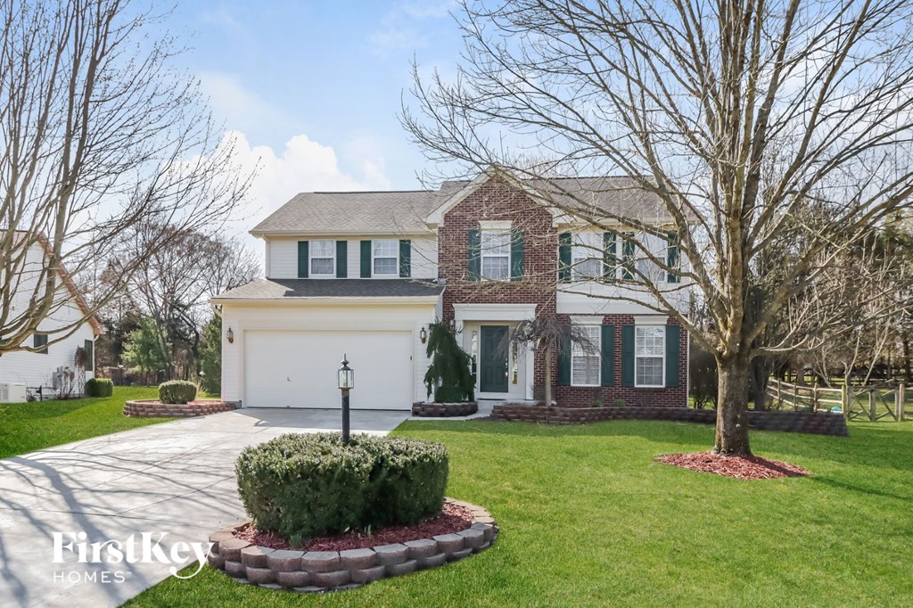 a brick house with a white garage door and a lawn