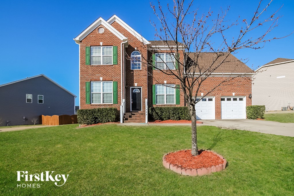 a house with a lawn and a tree in front of it