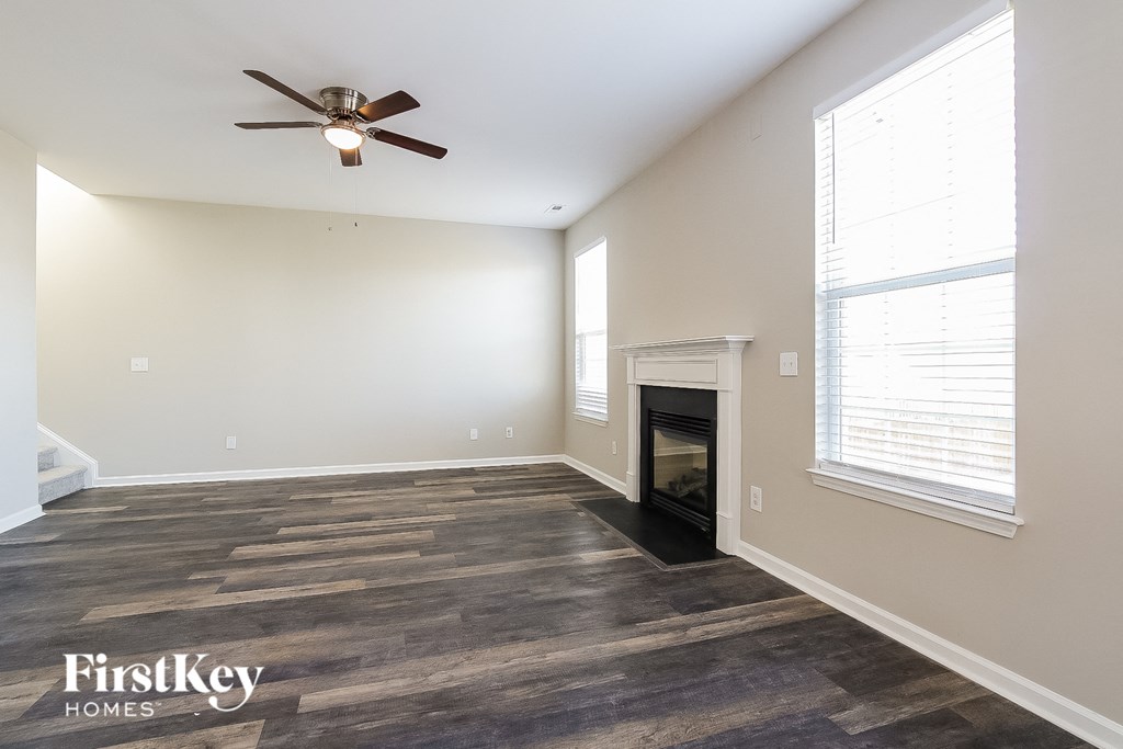 a living room with a fireplace and a ceiling fan