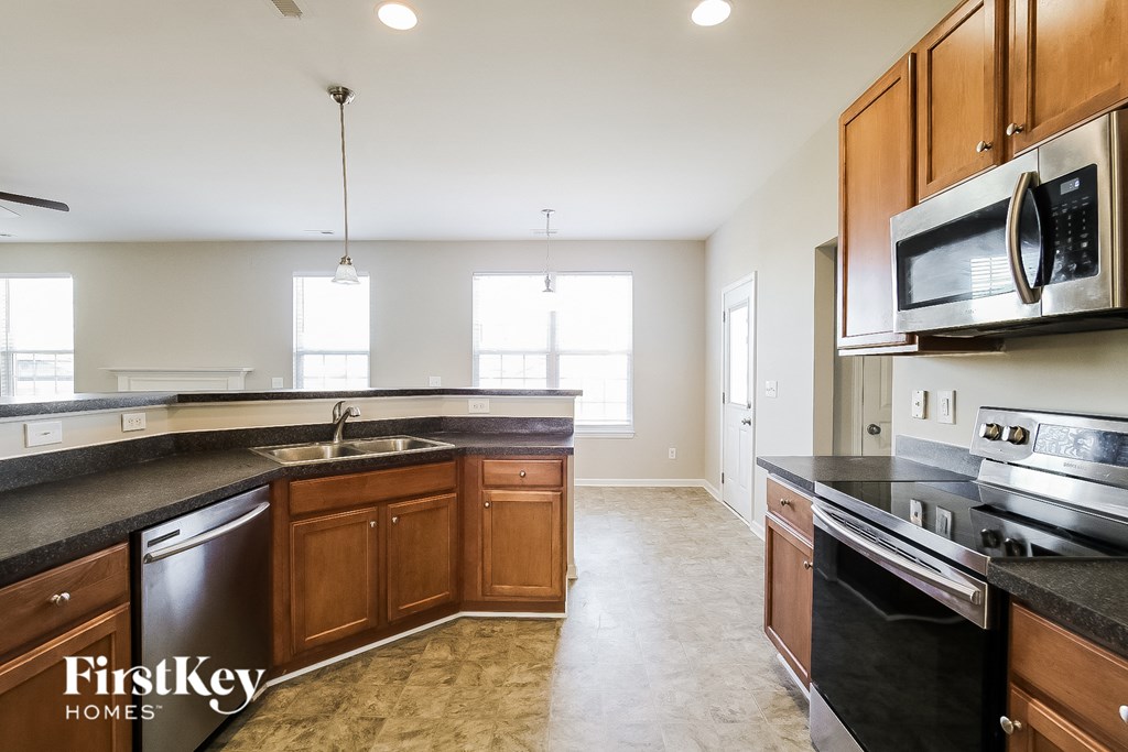 a kitchen with wooden cabinets and black counter tops and stainless steel appliances