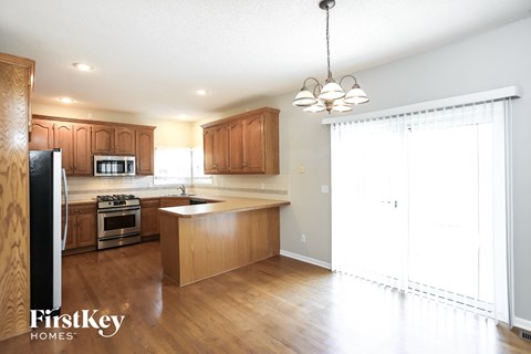 A kitchen with wooden cabinets and a stove top oven.