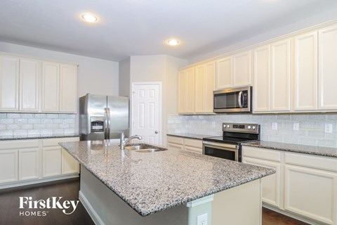 A kitchen with granite countertops and white cabinets.