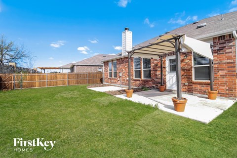 A house with a brick exterior and a covered patio area.