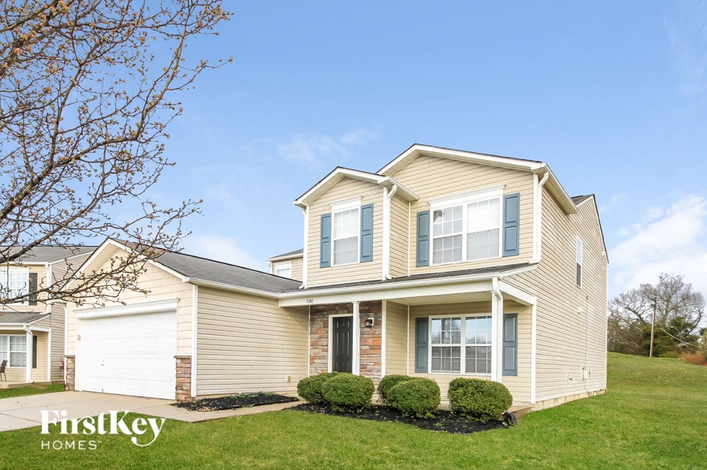 a yellow house with a lawn and a blue sky