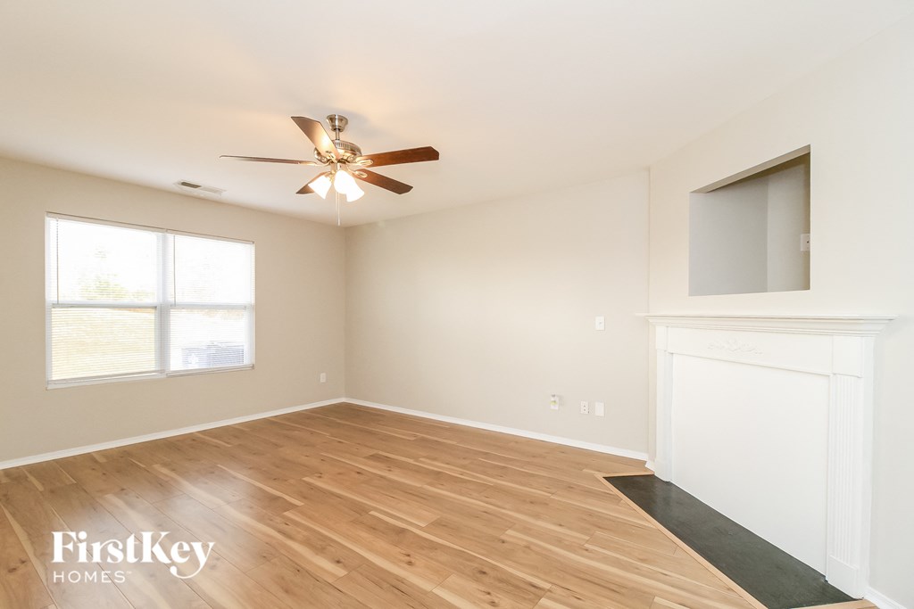 a living room with wood floors and a ceiling fan