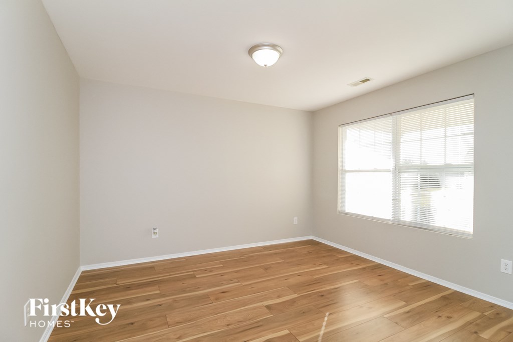 the living room of a house with wood floors and a window