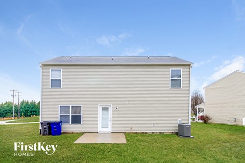 the exterior of a small house with a yard and grass