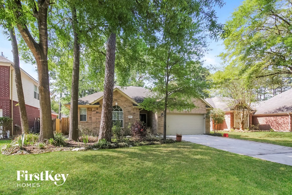 a house with trees in the yard and a driveway