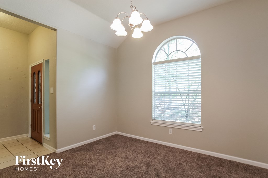 the second bedroom has a large window and carpeted flooring