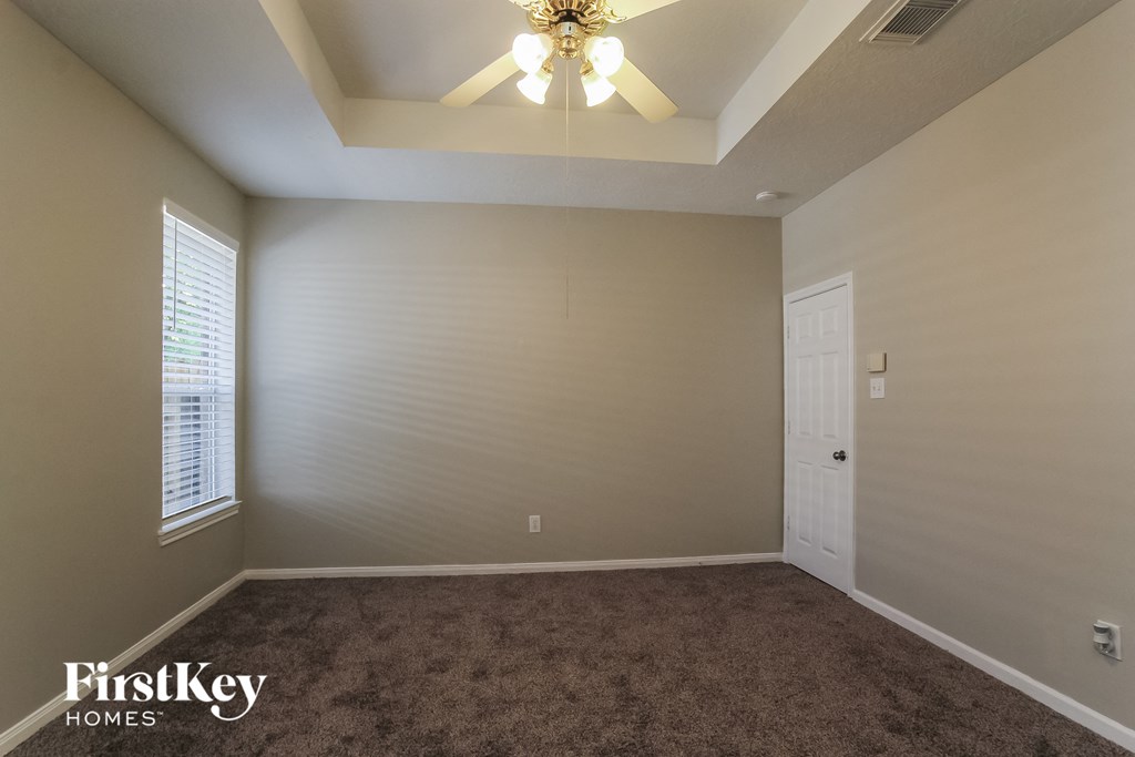 the upstairs bedroom with carpet and a ceiling fan