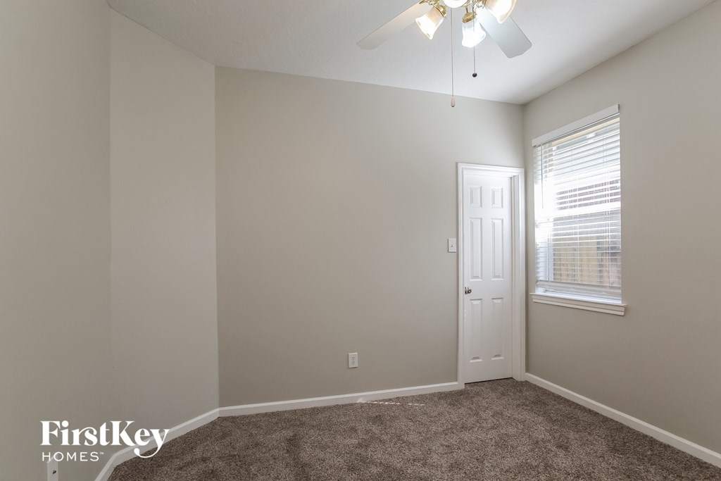 a bedroom with a ceiling fan and a window