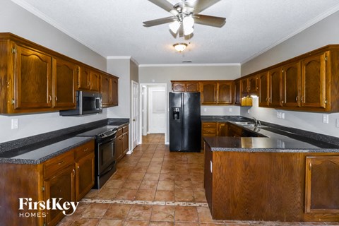 A kitchen with wooden cabinets and a black refrigerator.