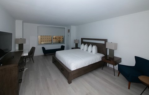 A bedroom with a bed, desk, and chair.