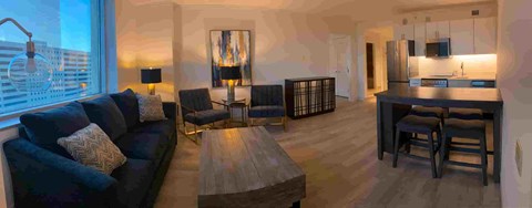 A modern living room with a dark blue sofa and wooden coffee table.