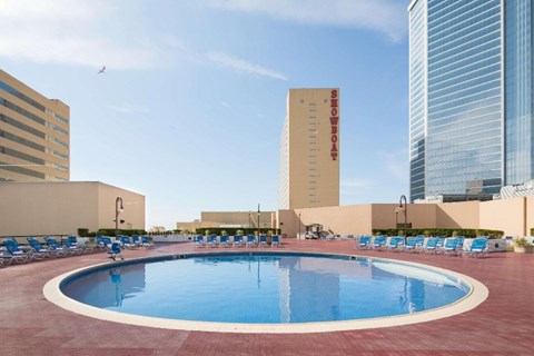 A round swimming pool surrounded by chairs in the middle of a city.