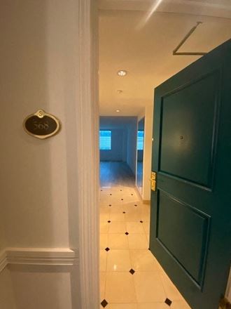 a hallway with a blue door and a white tiled floor
