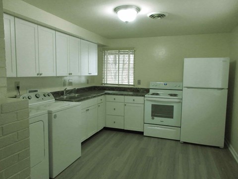 A kitchen with white appliances and cabinets.