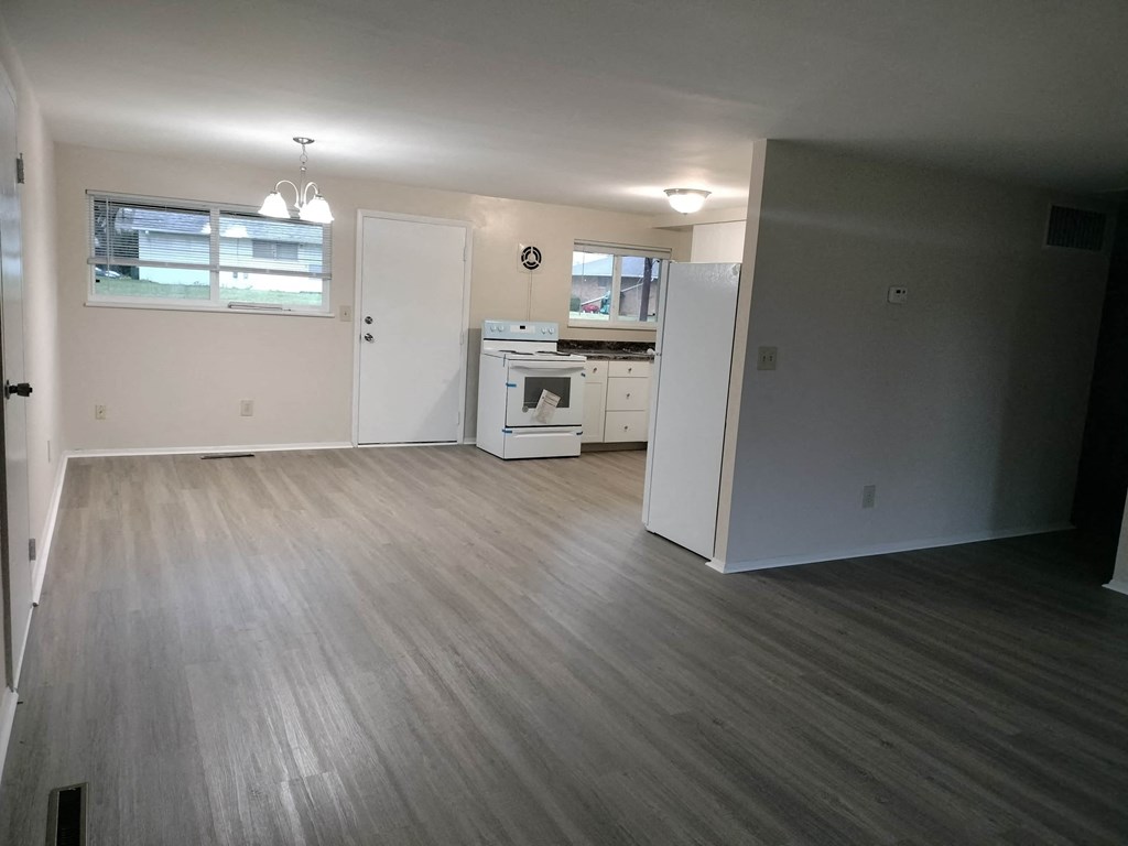a kitchen and living room with wood flooring and white appliances
