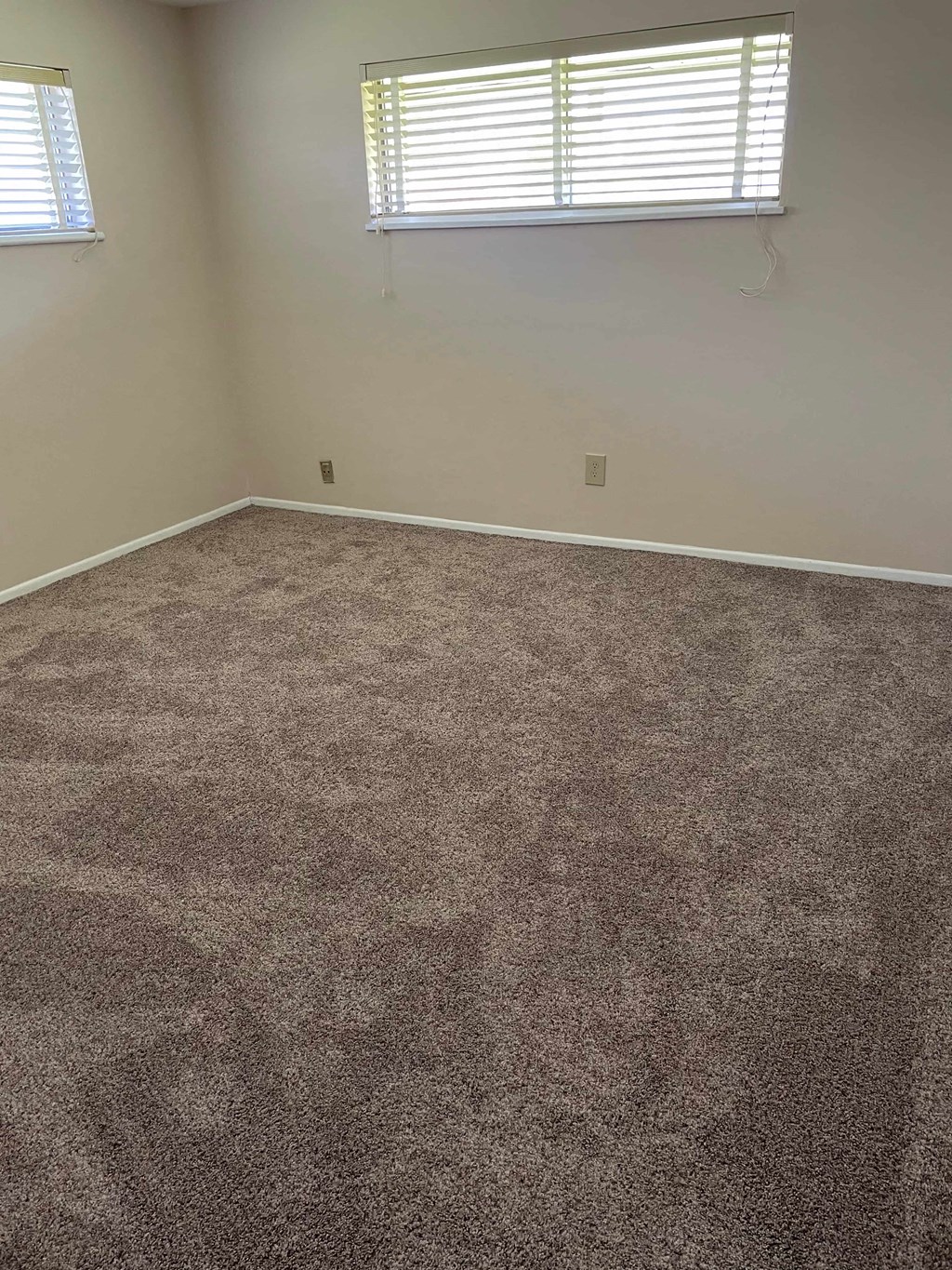 a carpeted room with a window and