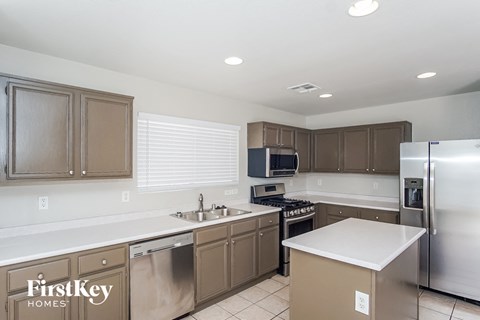 A kitchen with brown cabinets and a stainless steel refrigerator.