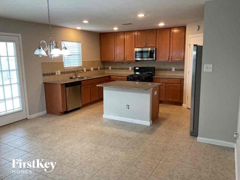 A kitchen with wooden cabinets and a white island.