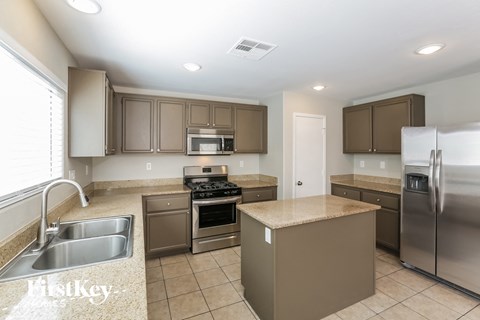 A kitchen with brown cabinets and a stainless steel refrigerator.