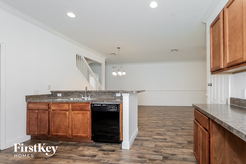 A kitchen with wooden cabinets and a granite countertop.