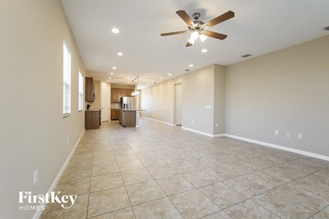 A spacious room with a ceiling fan and tiled flooring.