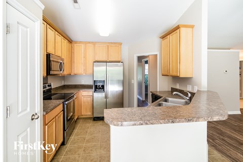 A kitchen with wooden cabinets and a granite countertop.