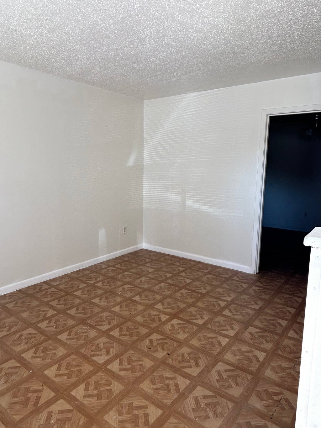 an empty room with a wooden floor and a black door