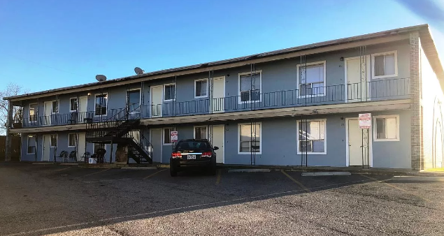 a car parked in front of an apartment building
