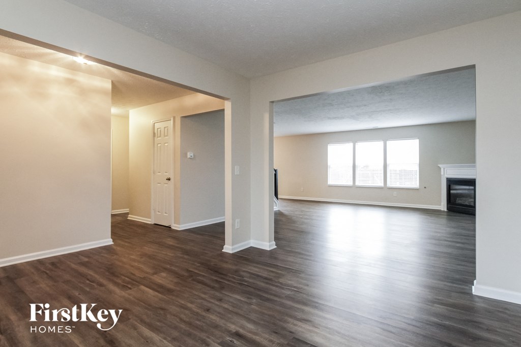 the living room and dining room of an empty house