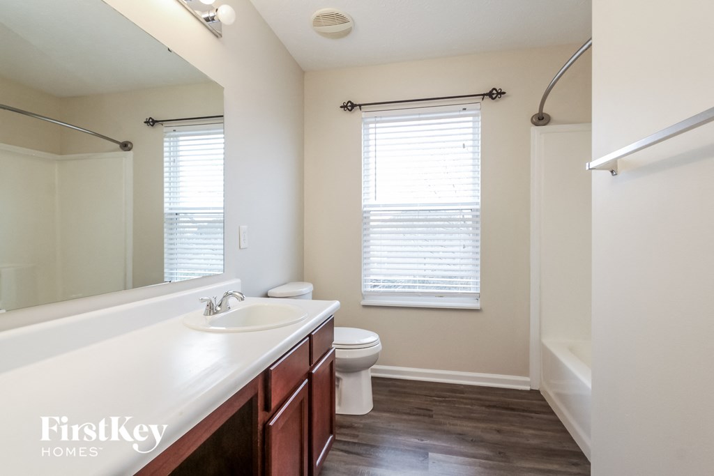 a bathroom with a large mirror and a sink and a toilet