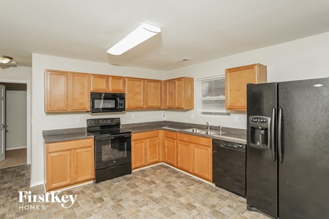 a kitchen with wood cabinets and black appliances and stainless steel appliances