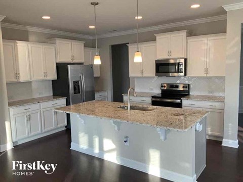 A kitchen with a granite countertop and white cabinets.
