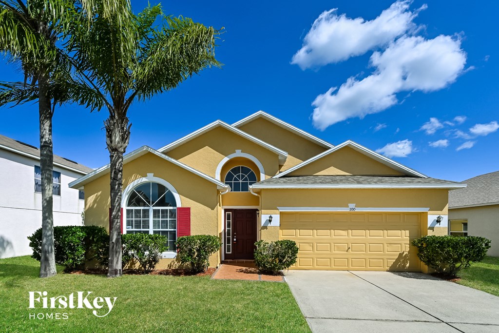 A yellow house with a palm tree in front of it.