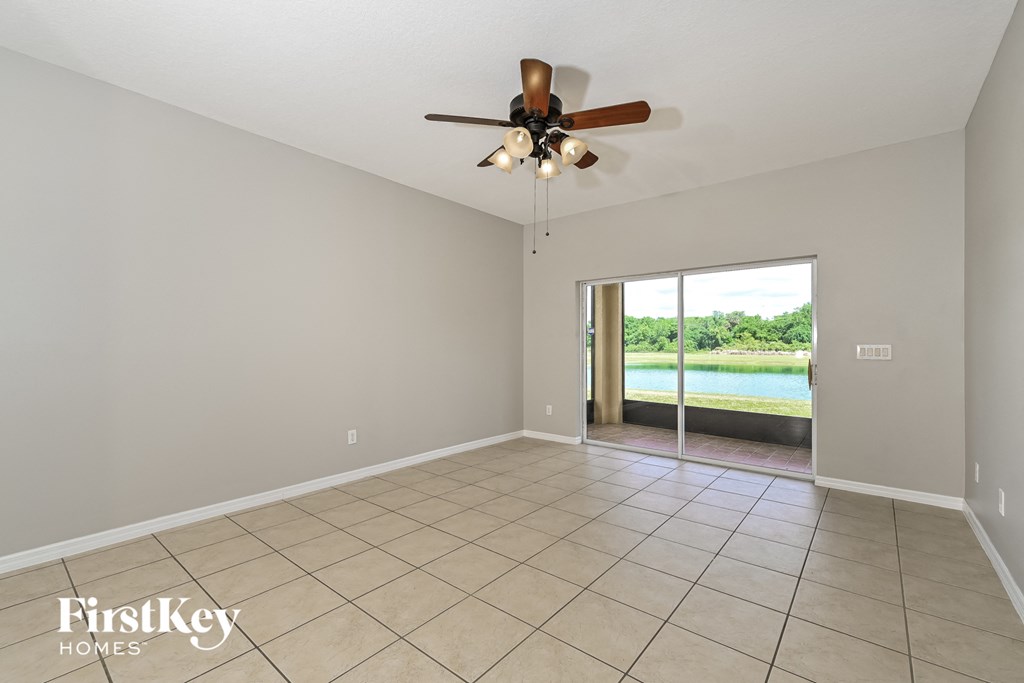 A spacious room with a ceiling fan and tiled floor.