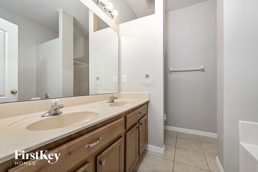 A bathroom with two sinks and a shower.