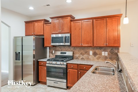 A kitchen with wooden cabinets and a stainless steel refrigerator.