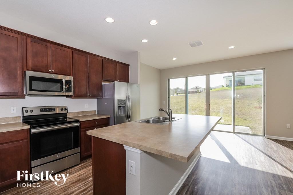 a kitchen with wooden cabinets and stainless steel appliances and a marble counter top