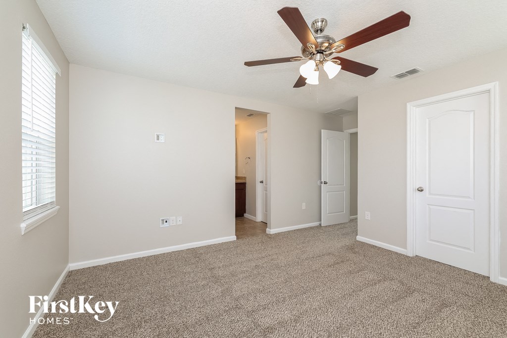 the living room of an empty house with a ceiling fan