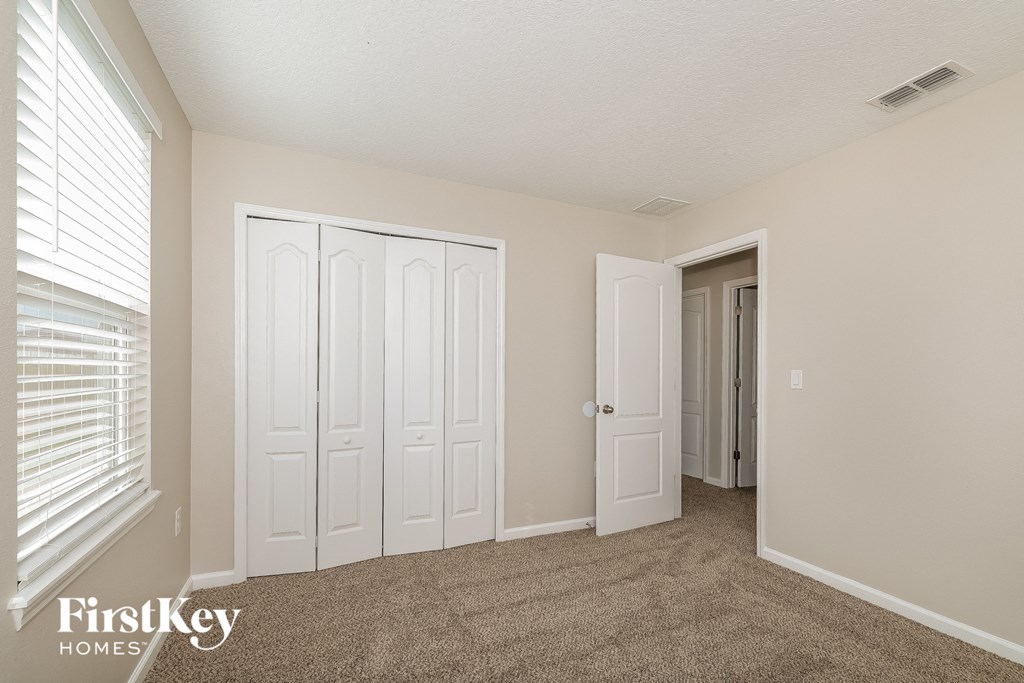 a bedroom with two closets and a door to a hallway